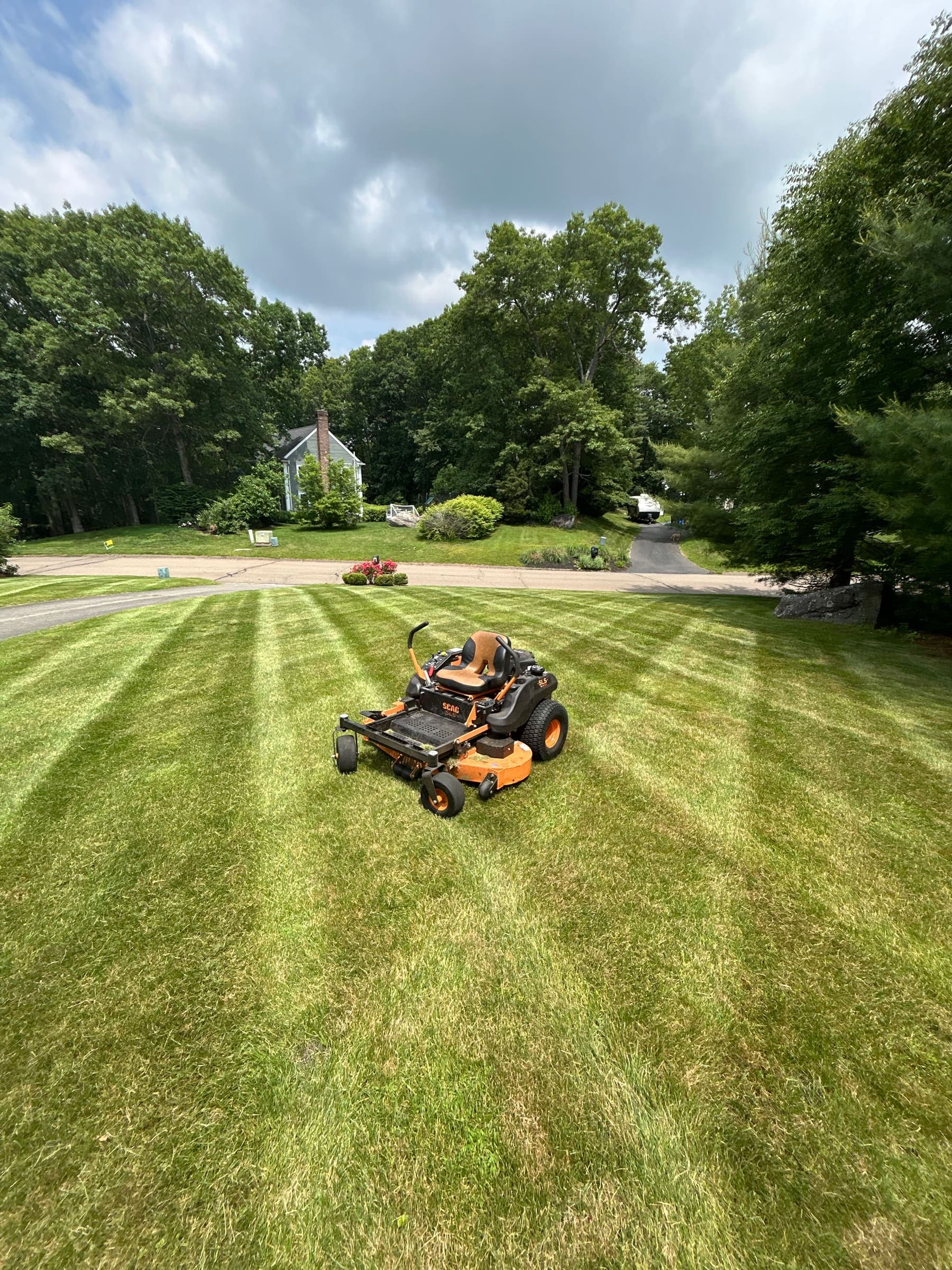 Triple G Landscaping's commercial zero-turn mower parked on a freshly cut lawn in Madison, CT